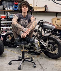 a man sitting on top of a motorcycle in a garage