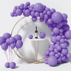 there is a wine bottle and some balloons in the shape of a circle on a table