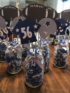 there are many blue and white decorations in glass jars with paper stars on the top