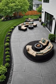 an outdoor patio with seating and fire pit in the middle, surrounded by green grass