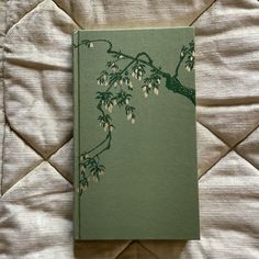 a green book sitting on top of a bed