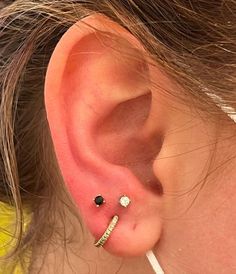 a close up of a person's ear with two piercings