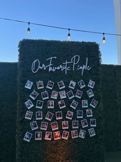 an outdoor wall with pictures and string lights hanging from it that says our favorite people