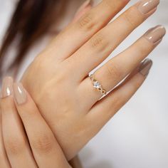 a woman's hand with a gold ring on it and two diamonds in the middle