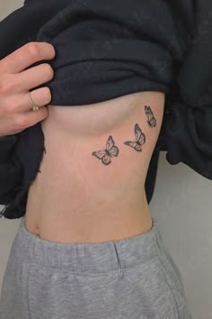 a woman's stomach with three butterflies on it