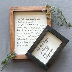 two framed pictures with writing on them sitting next to each other and flowers in the frame