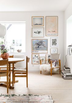 a dining room table with chairs and pictures on the wall