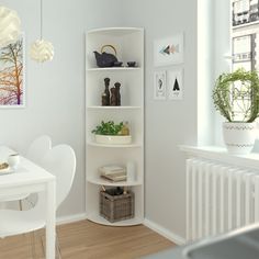 a room with white furniture and pictures on the wall, along with a table and chairs