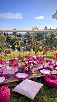 the table is set with pink and white plates, napkins, and place settings