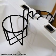 a white sink with a black wire basket on it