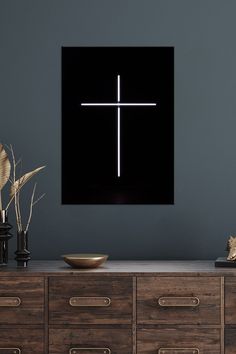 a cross on a black wall above a dresser