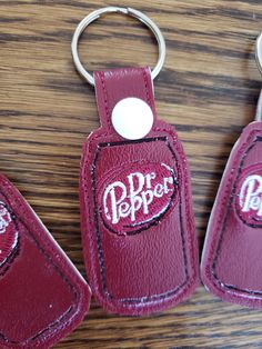 two red leather keychains with the word dr pepper on them