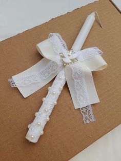 the wedding garter is tied with white ribbon and pearl beaded beads, along with a candle