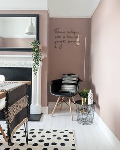 a living room with pink walls and black accents