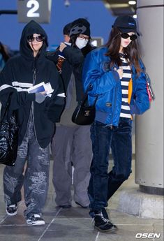 three people wearing face masks while standing next to each other