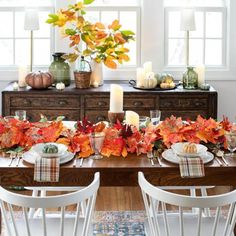 a dining room table decorated with fall leaves