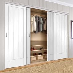 an open closet with white doors and drawers