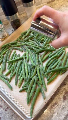 someone is grating green beans on a cutting board