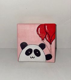 a panda bear with a heart balloon painted on it's face