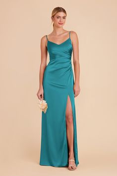 a woman in a long green dress with a slit down the side and one leg