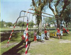 children are playing in the park on swings