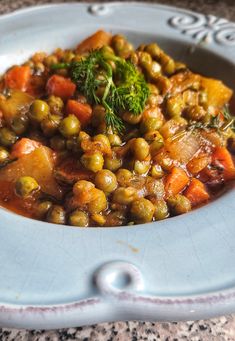 a bowl filled with peas and carrots on top of a table