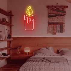 a neon lit candle on the wall above a bed