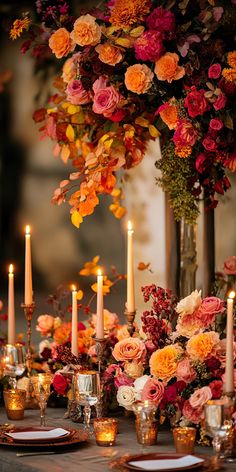 a table topped with lots of candles and flowers next to tall vases filled with flowers