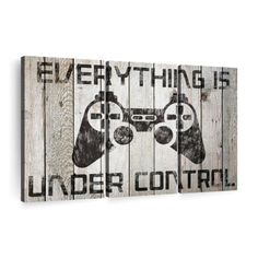 a wooden sign that says everything is under control with two video game controllers on it