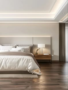 a large white bed sitting on top of a wooden floor