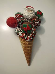 an ice cream cone filled with candy and candies, santa clause on the top