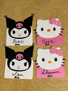 three hello kitty magnets with pink and black bows on them, one has a name tag