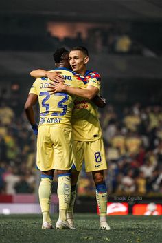 two soccer players are hugging each other on the field