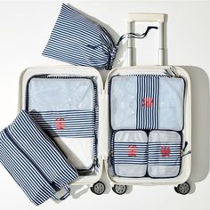 an open suitcase with four pieces of luggage on wheels and one piece of folded towels