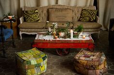 a living room filled with furniture and decor on top of a stone floored floor