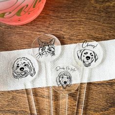 three dog and cat buttons on a white paper towel next to a pink ball with writing