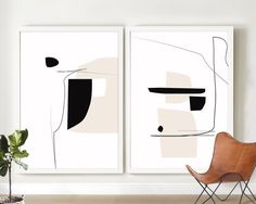 two black and white paintings hanging on the wall next to a chair with a plant in it