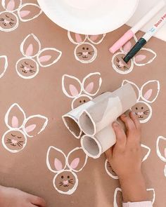 a child's hand holding a roll of toilet paper with bunny ears on it