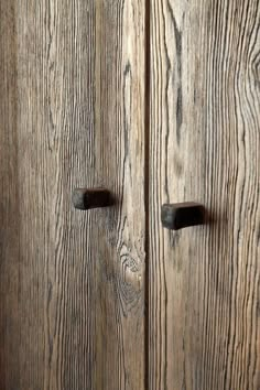 two wooden doors with black handles on them