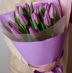 a bouquet of purple tulips wrapped in paper