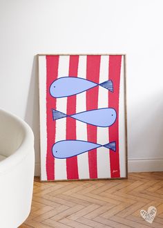 two fish on red and white striped background in front of a wall mounted art piece