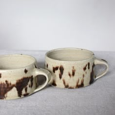 two brown and white cups sitting on top of each other