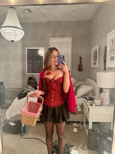 a woman taking a selfie in a mirror wearing a corset and holding a basket