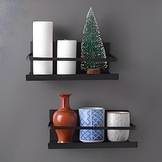 two black shelves with candles and vases on them