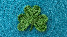 a green crocheted shamrock sitting on top of a blue table