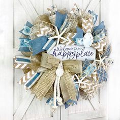 a wreath that says welcome to the happy place with blue and white ribbons on it