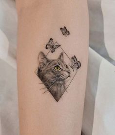 a cat and butterflies tattoo on the left thigh, with an image of a cat's face