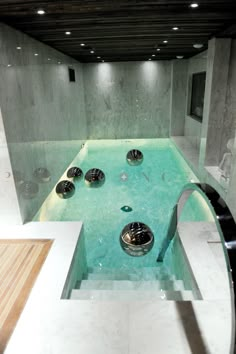 an indoor swimming pool with several bowls on the bottom and water running down the side