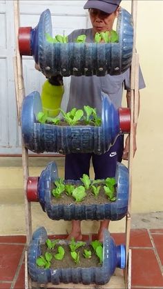 a man standing in front of a rack filled with green plants and water jugs