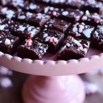 a pink cake plate topped with pieces of chocolate and sprinkled with candy canes